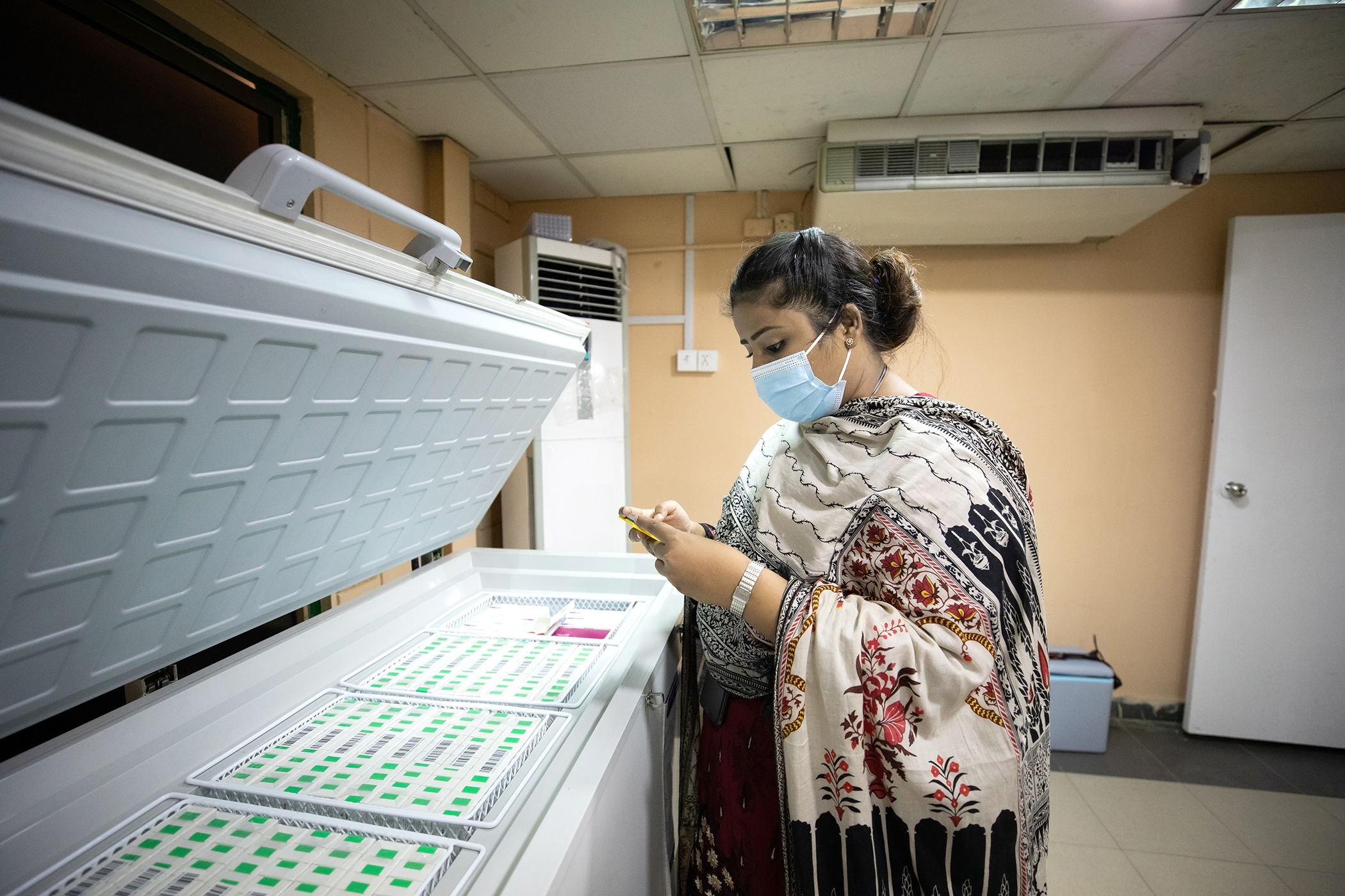Tahira Bano vérifie la température de réfrigération dans un centre de vaccination à Karachi, au Pakistan, le 5 juin 2021.
