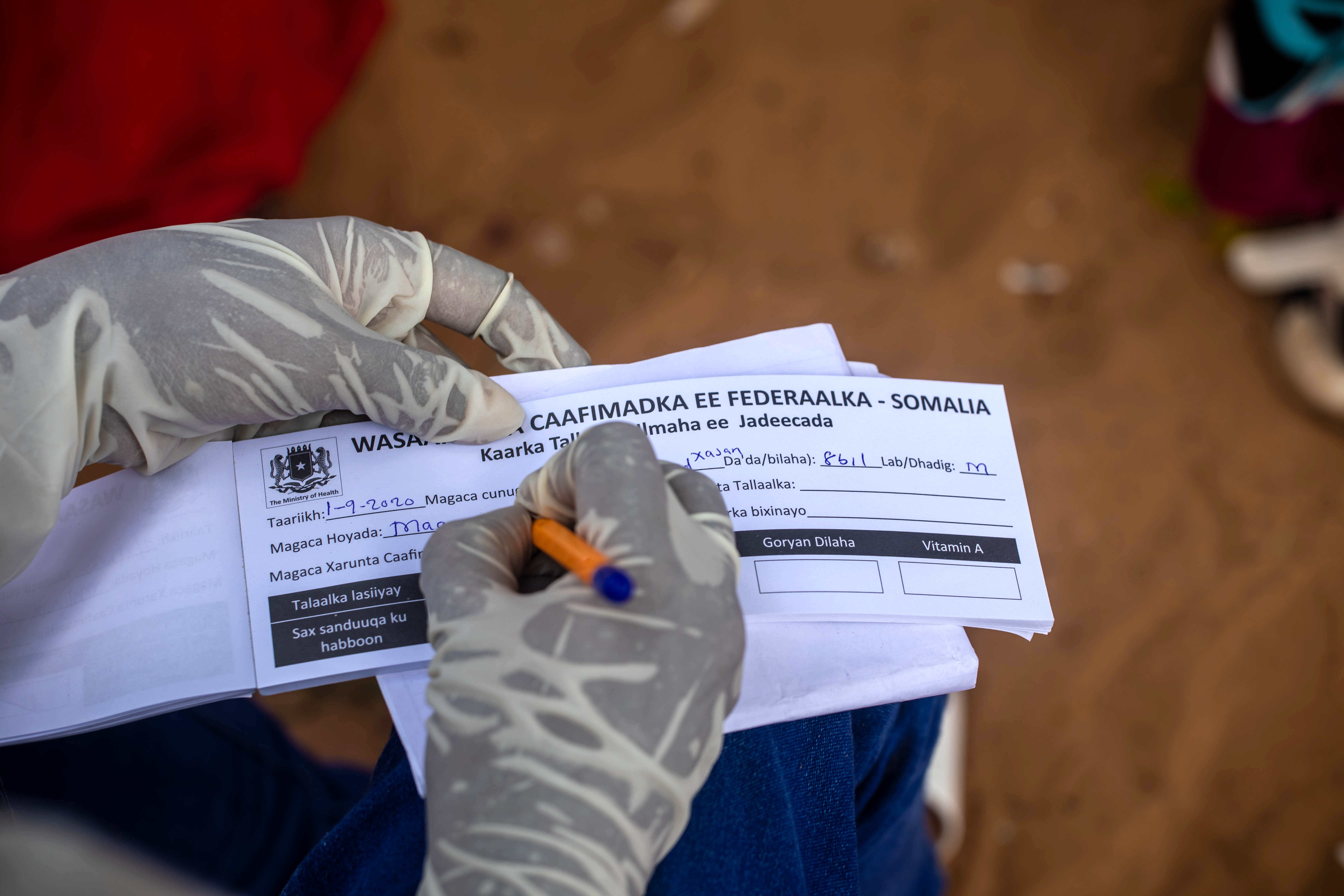 Un soignant remplit un document dans le cadre de la campagne de vaccination à Mogadiscio, Somalie,  en septembre 2020. Image : Ismail Taxta/OMS Somalie