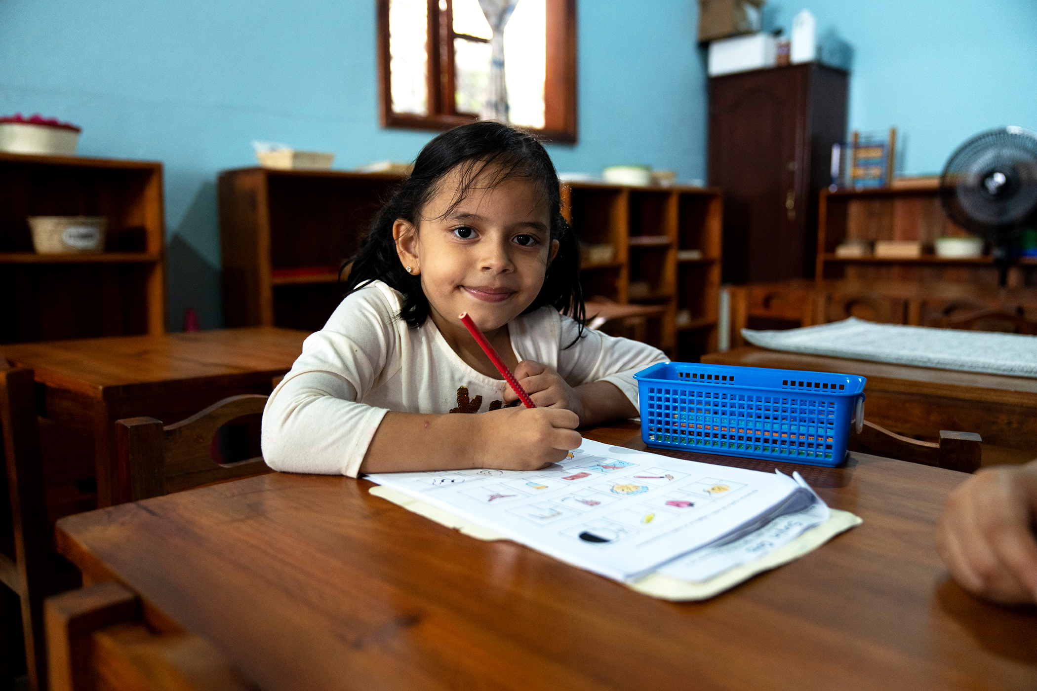 Une fille colorie une fiche d'apprentissage à Pasos Pequeñitos à Tegucigalpa.  Photo : Tomas Ayuso pour Global Citizen