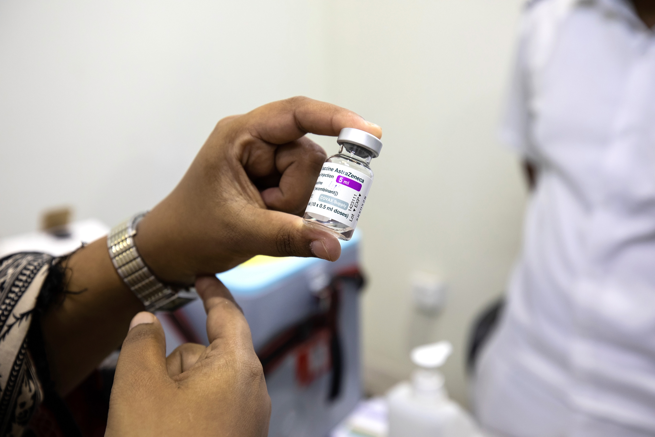 Tahira Bano tient un flacon du vaccin AstraZenecca contre la COVID-19 dans un centre de vaccination à Karachi, au Pakistan, le 5 juin 2021.  En moyenne, près de 3 000 personnes sont vaccinées chaque jour à Karachi Est.