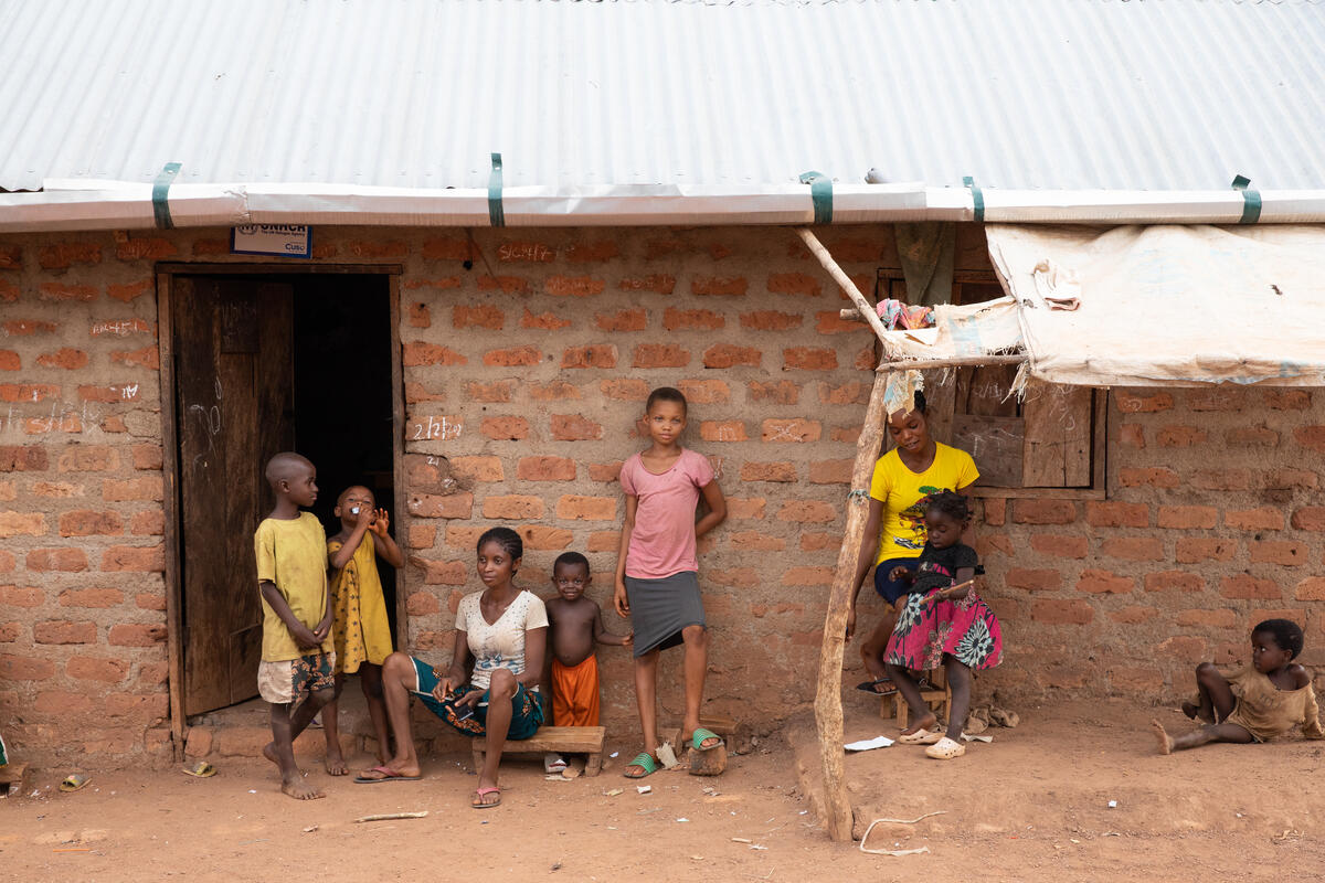 Okowo, 26 ans, et ses enfants Rema, 8 ans, Esther, 4 ans, et Jemima, 11 ans, devant sa maison dans un camp de réfugiés de l'État de Cross River, au Nigeria.  Tom Maguire / Save the Children