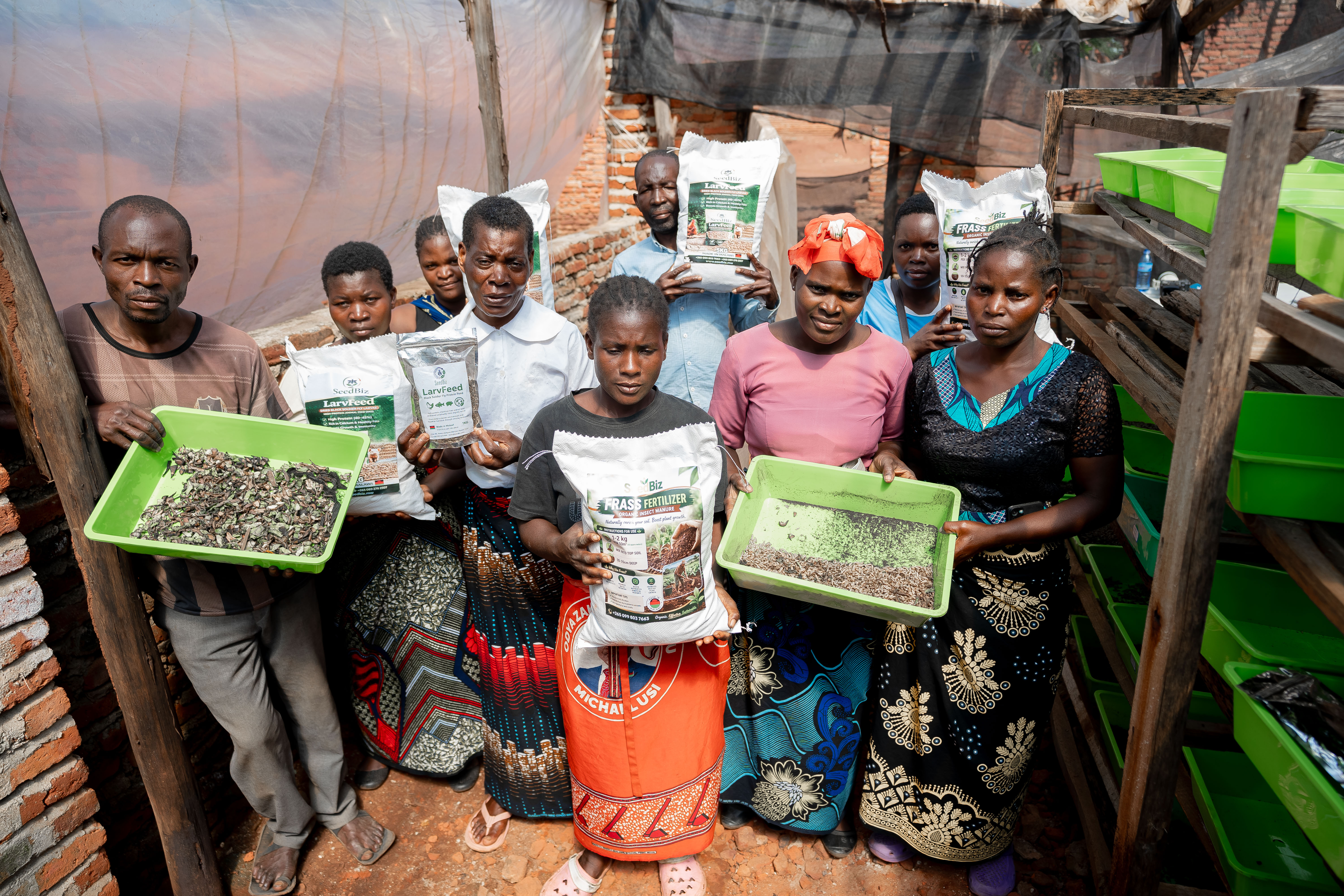 Farmers and community members display SeedBiz’s organic fertilizer and livestock feed products, developed by Global Prize winner Tawonga Nyirenda to make farming more affordable, productive, and climate-smart. Image: Robert Edward Phiri for Global Citizen