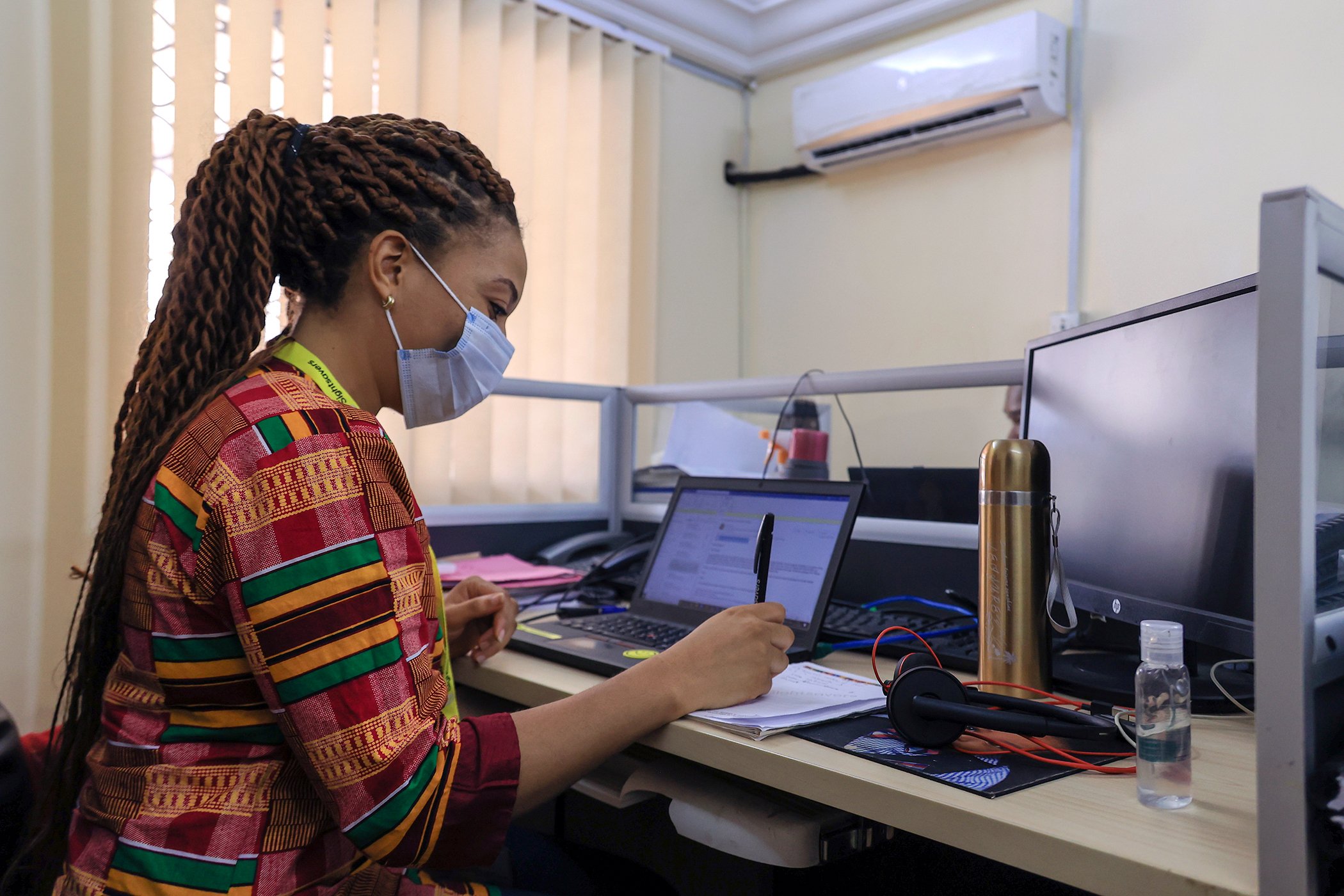 Kareen Atekem takes notes at the Sightsavers headquarters in Yaoundé, Cameroon. "Since the beginning of the COVID-19 pandemic, we have been doing a lot of teleworking... and the staff is reduced here at the NGO's headquarters," explained Atekem. Kareen Atekem_NTDActivist_Daniel BeloumouForGlobalCitizen_003.jpg